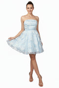 Woman wearing a light blue strapless dress on a white background